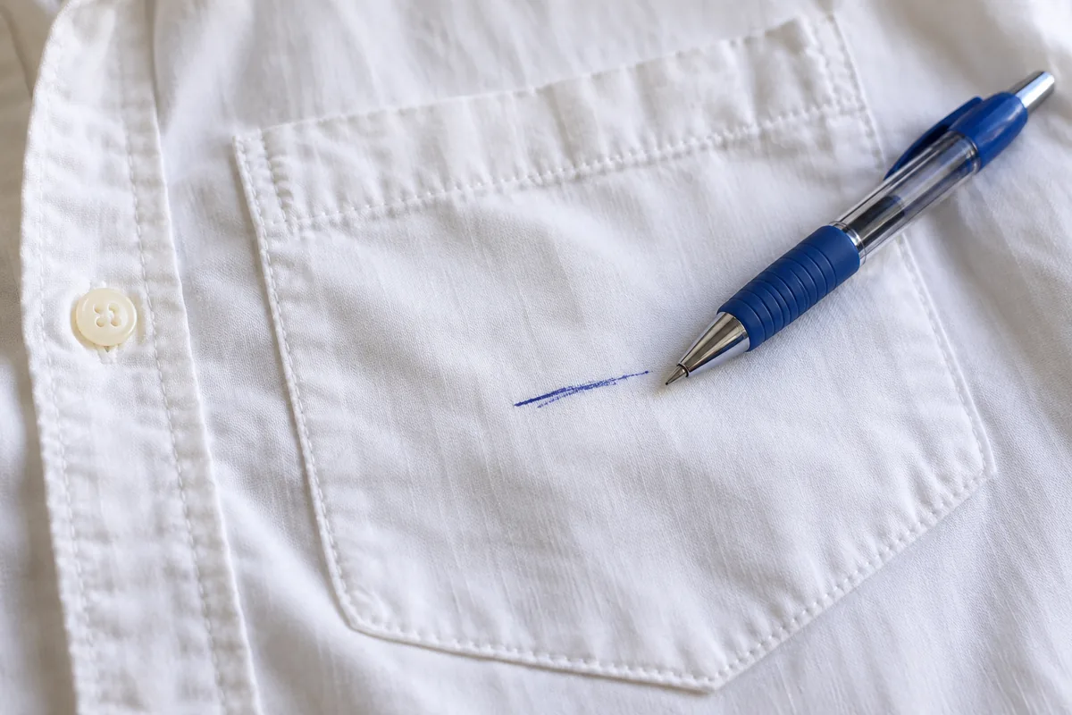 Marque d’encre bleue sur une poche de chemise.